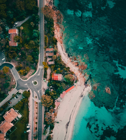 Vue aérienne captivante d'une plage idyllique à Ajaccio, mettant en avant l'harmonie des eaux cristallines et du sable doré, avec une invitation à l'exploration de ce paysage méditerranéen.