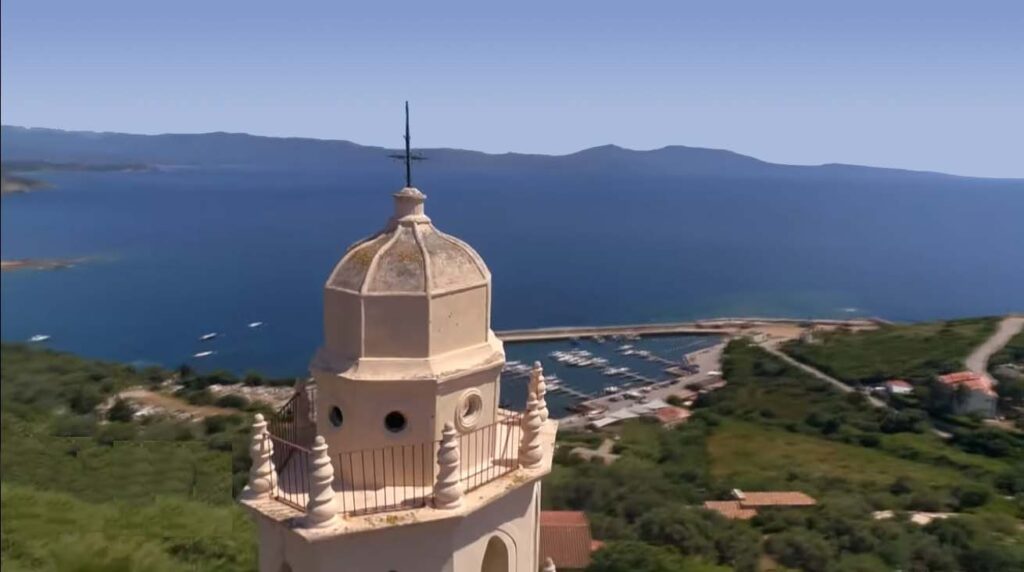 Vue aérienne de Cargèse en Corse, mettant en avant son port pittoresque, ses eaux méditerranéennes d'un bleu éclatant et le charme incomparable de ses paysages naturels.