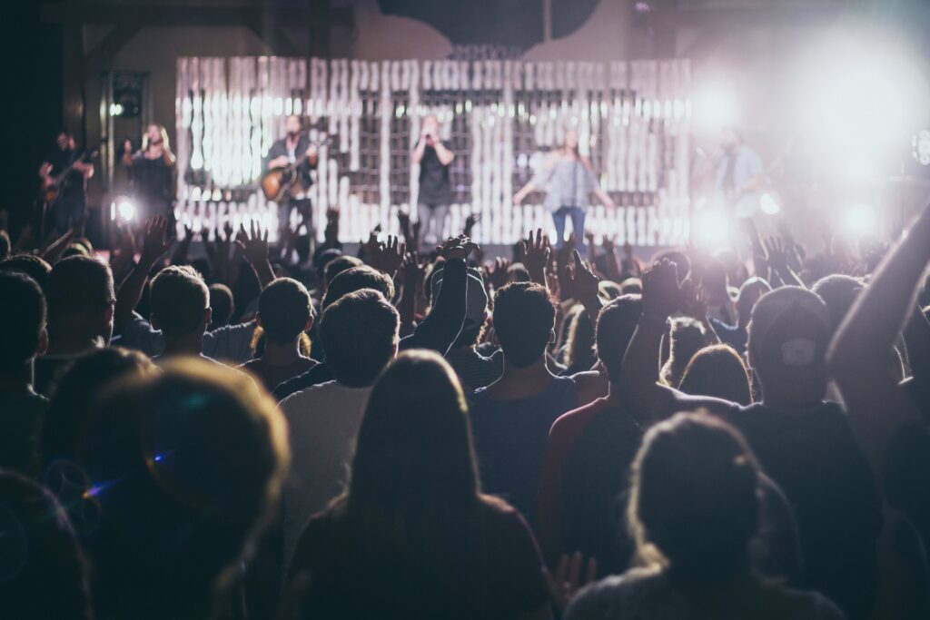 Image d'un concert capturant une fervente connexion entre artistes et public, au cœur d'une foule exaltée.