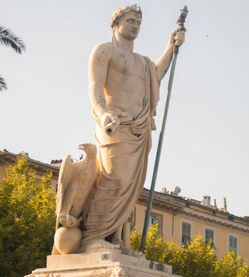Statue historique d'un personnage tenant un sceptre, avec un aigle symbolisant la puissance et la liberté, éclairée pour révéler des détails raffinés.