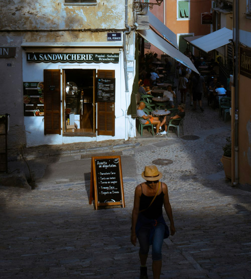 Cette image montre une sandwicherie au cœur d'une ruelle animée avec une ambiance chaleureuse, idéale pour savourer des plats faits maison.