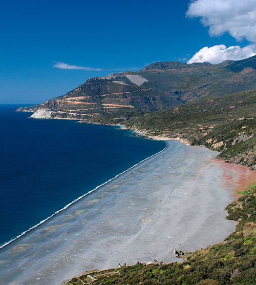 Photographie saisissante de la plage corse, mer azur et montagnes majestueuses pour une expérience nature et sérénité.