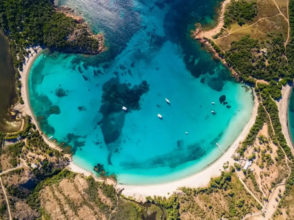 Plage de Palombaggia vue du ciel – Corse du Sud Vue aérienne spectaculaire de la plage de Palombaggia à Porto-Vecchio, en Corse, montrant la baie turquoise et la forêt de pins.
