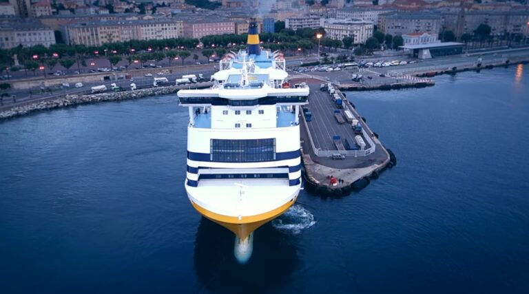 Ferry majestueux arrivant au port de Bastia, Corse, avec en fond les bâtiments colorés de la ville insulaire.