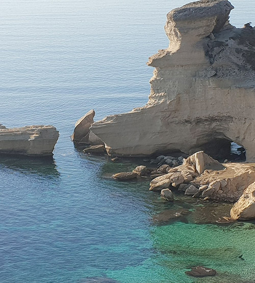 Cette image capture la sérénité de la côte corse où des rochers façonnés par l'érosion bordent une mer cristalline, évoquant un paysage de calme et d'évasion.