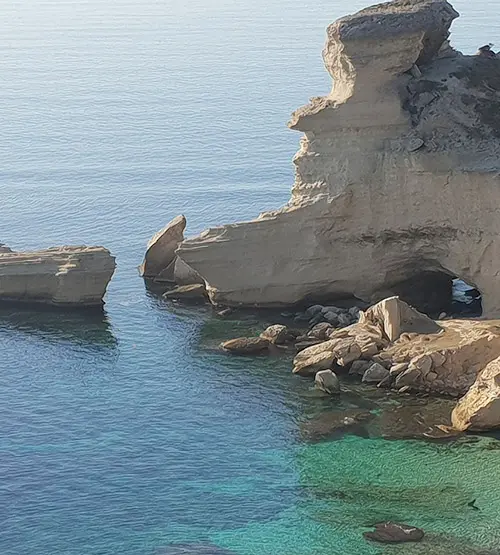 Cette image capture la sérénité de la côte corse où des rochers façonnés par l'érosion bordent une mer cristalline, évoquant un paysage de calme et d'évasion.
