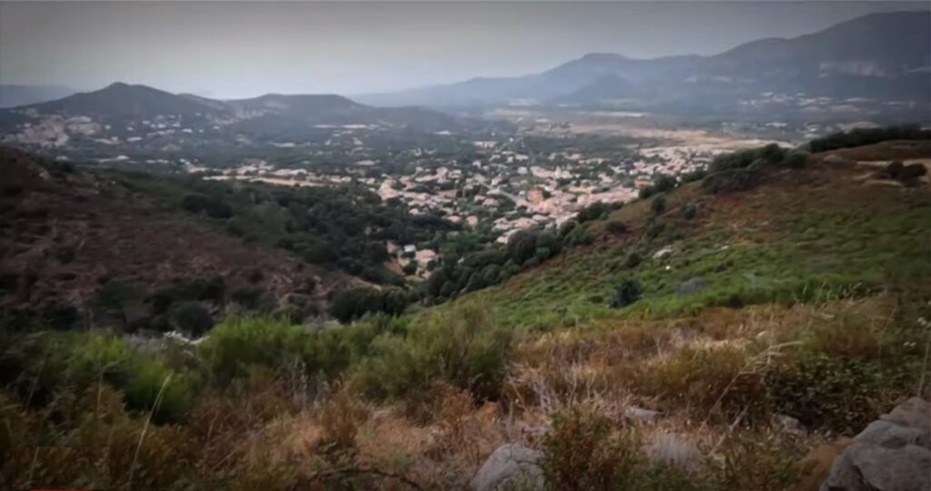 Vue panoramique d'un village niché au cœur des montagnes verdoyantes, reflétant beauté et sérénité.