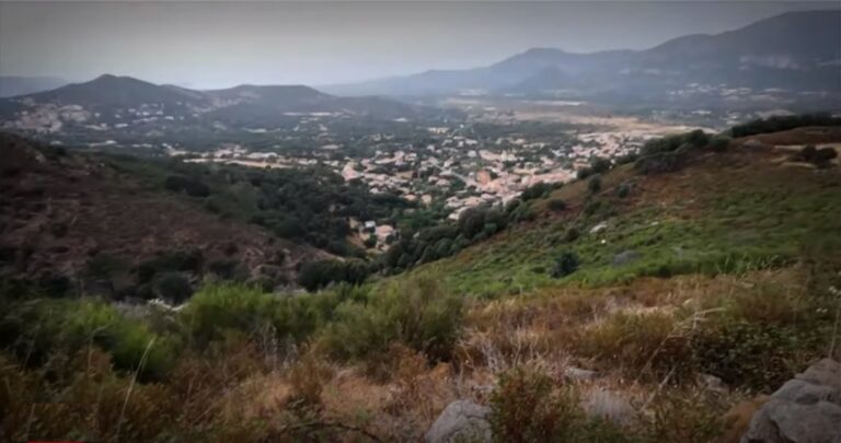 Vue panoramique d'un village niché au cœur des montagnes verdoyantes, reflétant beauté et sérénité.