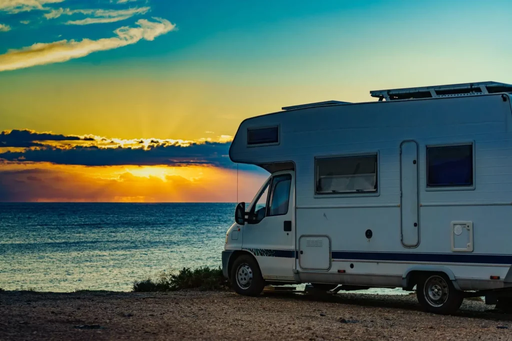 Camping-car face à la mer au coucher du soleil