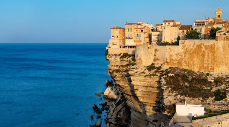 Vue magnifique du village de Bonifacio en Corse, perché sur ses falaises, avec une architecture harmonieuse et un paysage côtier méditerranéen.