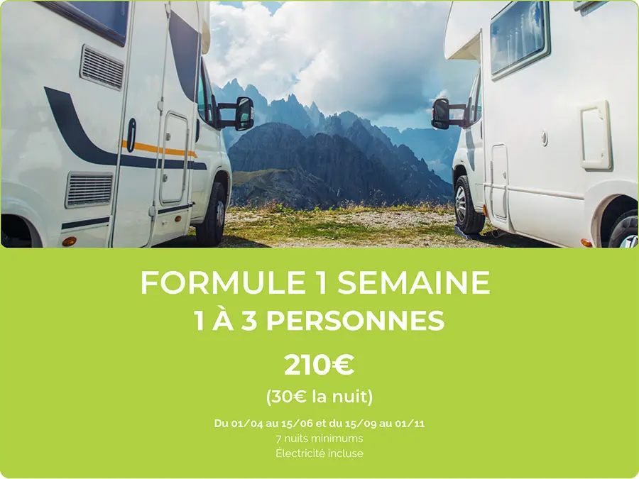 Une majestueuse vallée montagneuse avec camping-cars entourés par des montagnes et un ciel nuageux, parfaite pour une aventure en plein air.