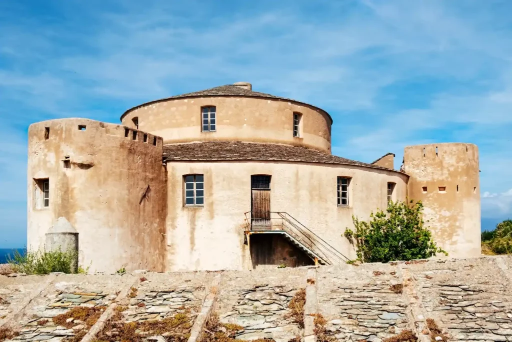 Citadelle de la ville de Saint-Florent Citadelle circulaire de Saint-Florent en Corse sous un ciel bleu, architecture militaire génoise historique avec tours de guet.